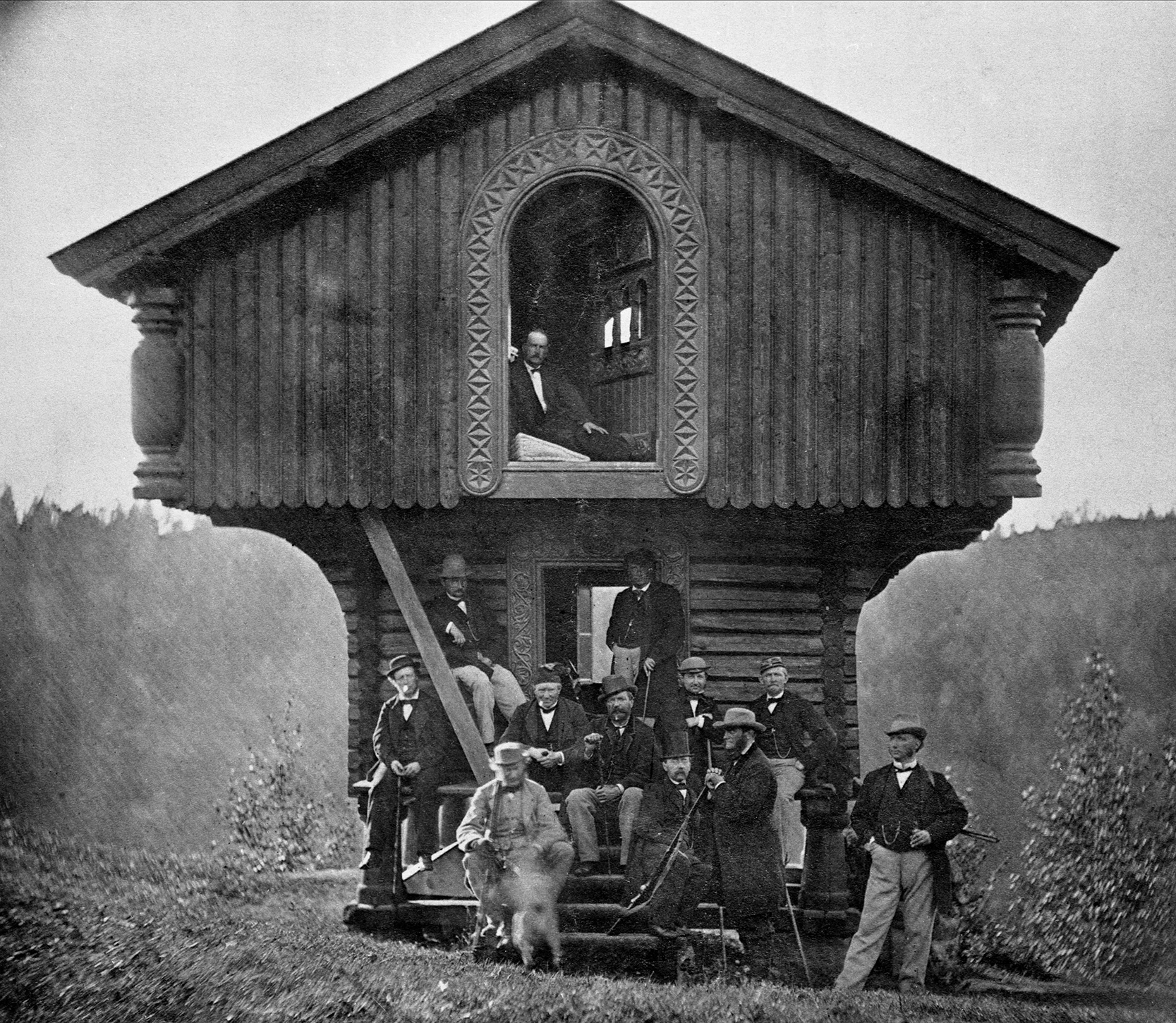 Thomas Heftye og en gruppe mennesker poserer foran hytten på Sarabråten, en del av hans arv som friluftsmann og bidrag til turismen i Oslo-regionen